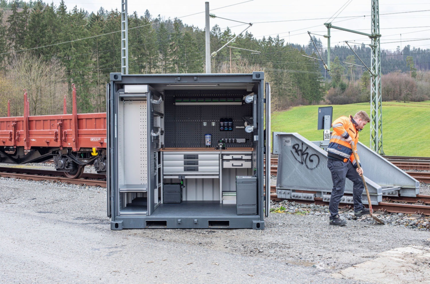 Container-værksted med robust køretøjsindretning til varige projekter inden for vejbygning, jordarbejde samt have- og landskabspleje.